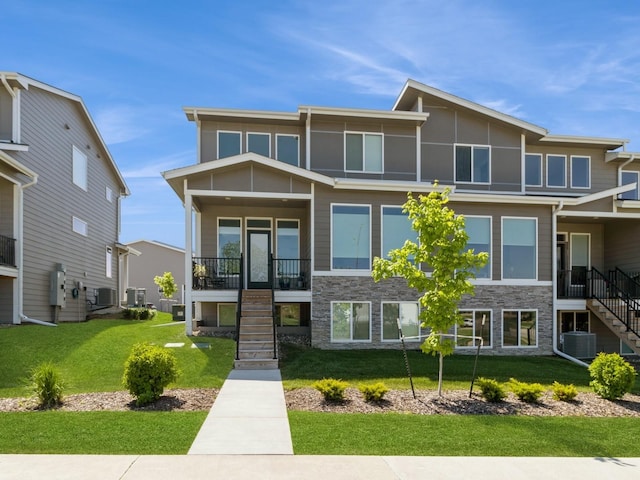 view of front of home with cooling unit and a front lawn