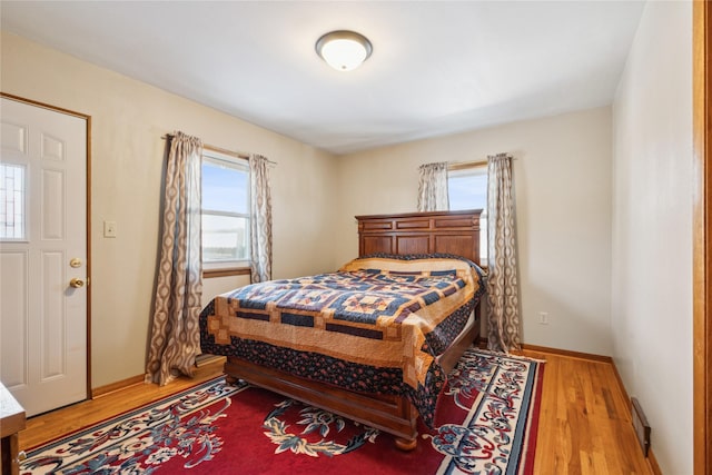 bedroom with light hardwood / wood-style floors and multiple windows