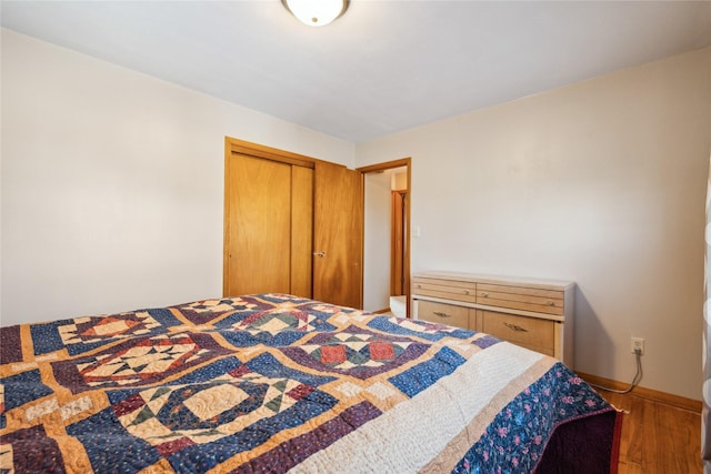 bedroom with dark wood-type flooring and a closet