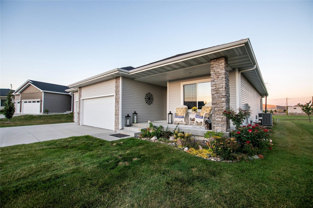 ranch-style home featuring central AC and a lawn