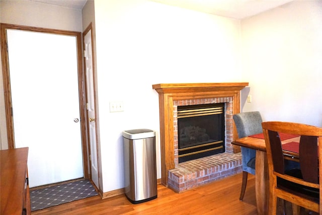 living area with a brick fireplace and hardwood / wood-style floors