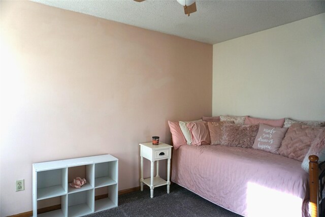 bedroom featuring a textured ceiling, ceiling fan, and dark carpet