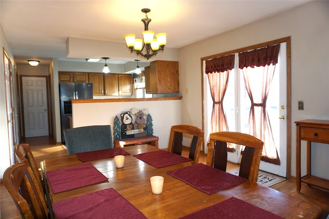 dining space with wood-type flooring and a notable chandelier