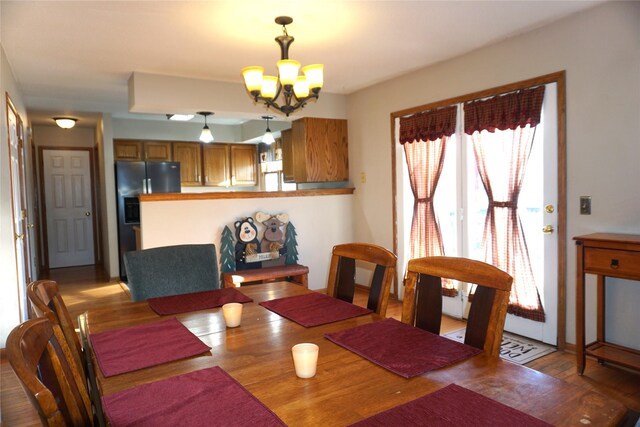 dining area featuring wood finished floors and a chandelier