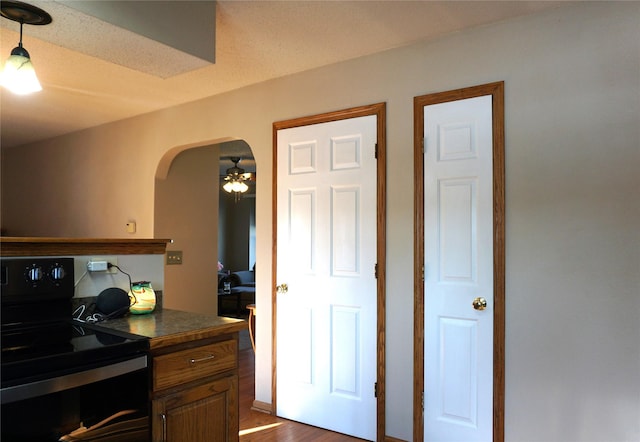 kitchen with ceiling fan, dark wood-type flooring, and black range with electric stovetop