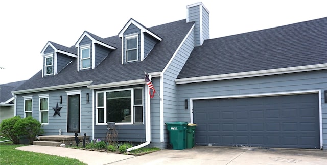 cape cod home with a chimney, roof with shingles, driveway, and an attached garage