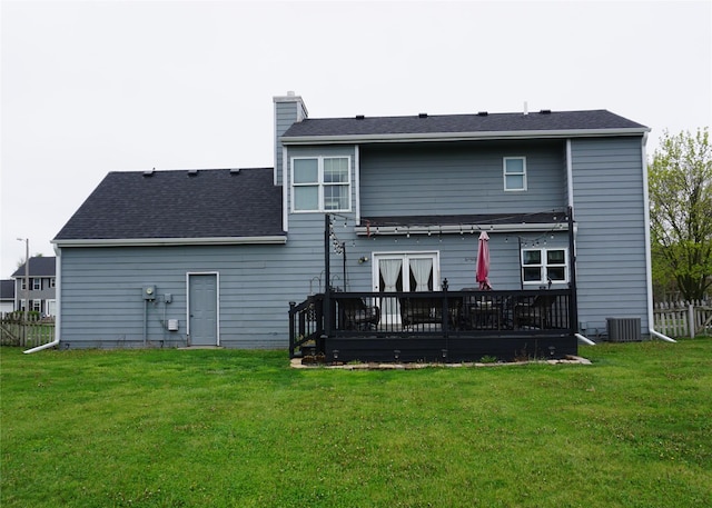 back of house with a wooden deck, a lawn, central AC, a chimney, and fence