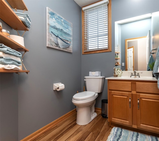 bathroom with hardwood / wood-style floors, toilet, and vanity