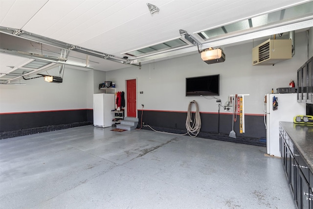 garage featuring white fridge and a garage door opener