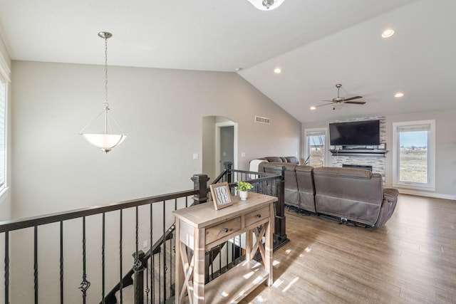 living room with lofted ceiling, ceiling fan, a fireplace, and hardwood / wood-style floors