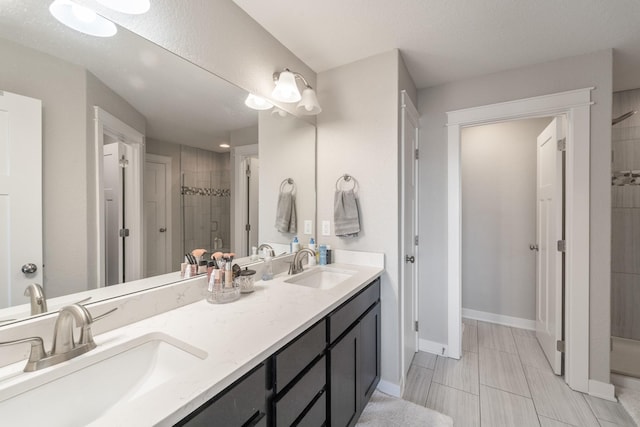 bathroom featuring a textured ceiling, an enclosed shower, and vanity