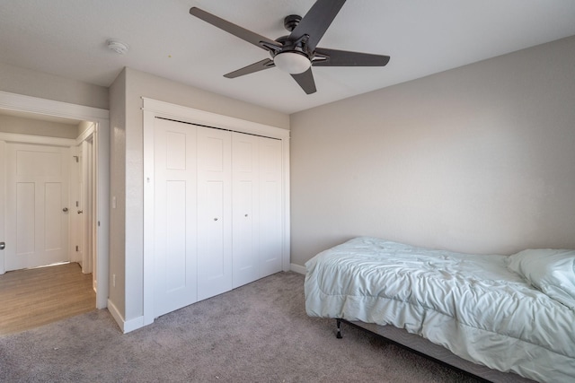 bedroom with ceiling fan, a closet, and light carpet