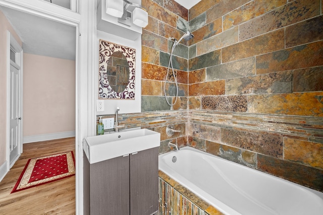 bathroom featuring tiled shower / bath combo, wood-type flooring, and vanity