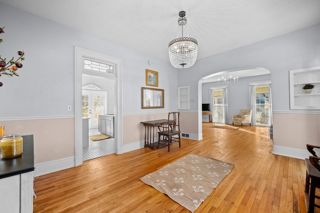 entryway featuring a healthy amount of sunlight, light hardwood / wood-style flooring, and a notable chandelier