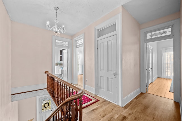 foyer featuring a notable chandelier, a textured ceiling, and light hardwood / wood-style floors