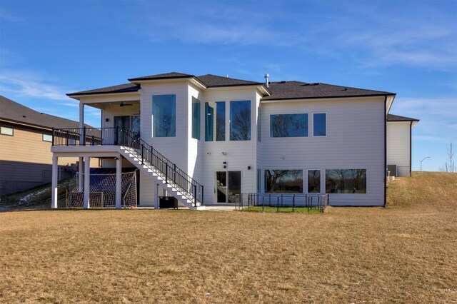 rear view of property featuring ceiling fan and a lawn