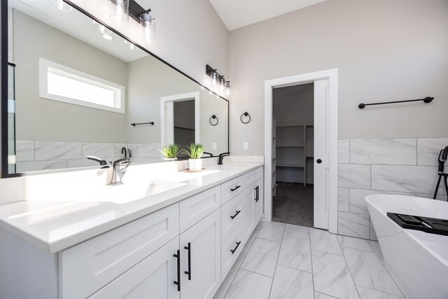 bathroom with a bathing tub, tile walls, and vanity