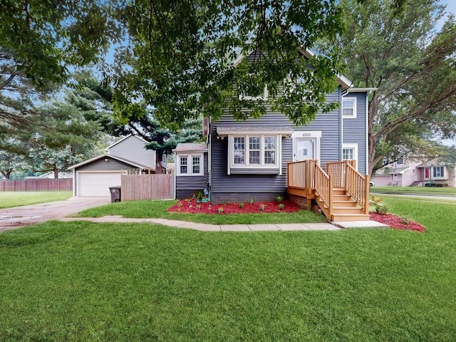 view of front of home with a front yard, a garage, and an outbuilding