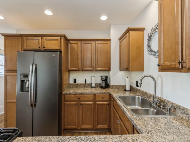 kitchen featuring stainless steel refrigerator with ice dispenser and sink