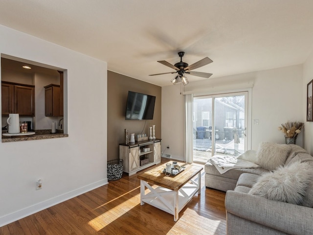 living room featuring ceiling fan and dark hardwood / wood-style flooring