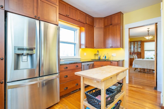 kitchen with light wood-type flooring, stainless steel appliances, plenty of natural light, and sink