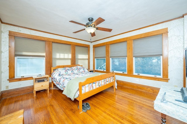 bedroom with ceiling fan, wood-type flooring, and crown molding