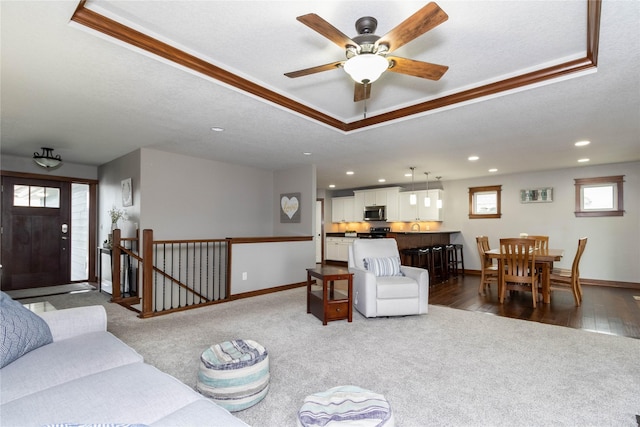 carpeted living room featuring ceiling fan and ornamental molding