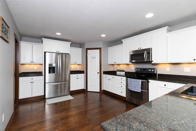 kitchen featuring appliances with stainless steel finishes, dark hardwood / wood-style flooring, and white cabinetry