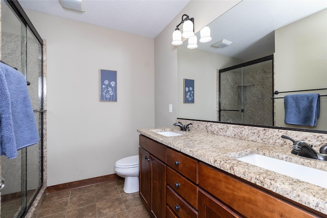 bathroom featuring toilet, tile patterned floors, a shower with shower door, and vanity