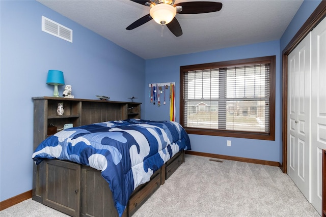 carpeted bedroom featuring ceiling fan and a closet