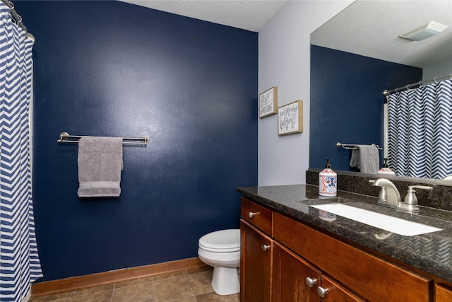 bathroom featuring a textured ceiling, toilet, and vanity