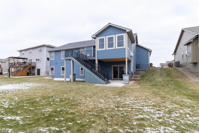 back of property with a wooden deck, a patio area, a yard, and central AC