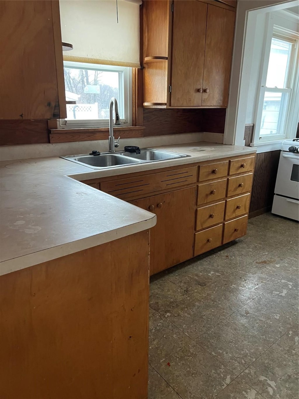 kitchen featuring white gas range, sink, and a wealth of natural light