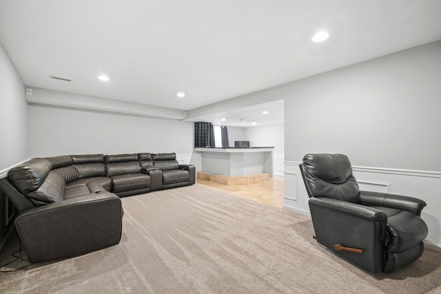 living area featuring light carpet, a wainscoted wall, and recessed lighting