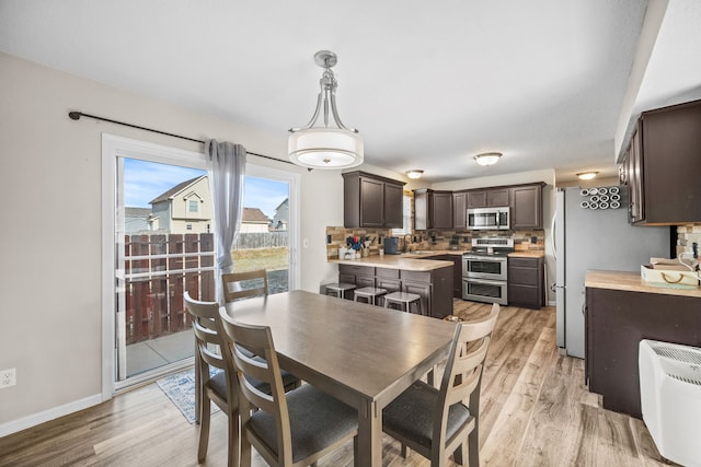 dining room featuring sink and light hardwood / wood-style flooring