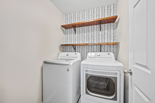 laundry room featuring laundry area, a textured ceiling, and washer and dryer