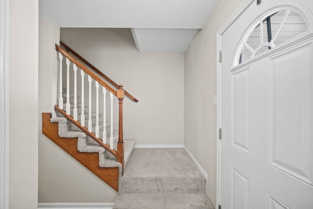 stairs featuring carpet floors and baseboards