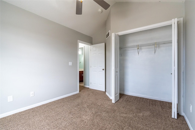 unfurnished bedroom with ceiling fan, vaulted ceiling, carpet floors, and a closet