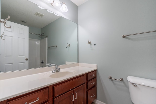 bathroom with toilet, walk in shower, and vanity