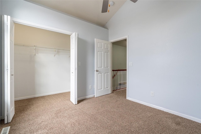 unfurnished bedroom featuring vaulted ceiling, ceiling fan, carpet flooring, and a closet