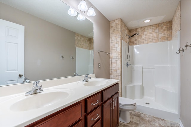 bathroom featuring a shower, toilet, and vanity