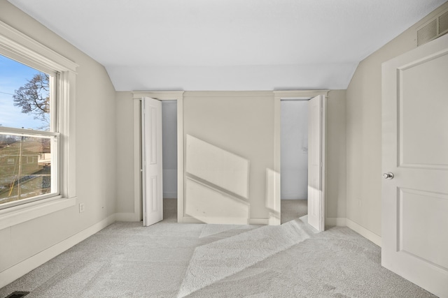 bedroom with lofted ceiling and light colored carpet