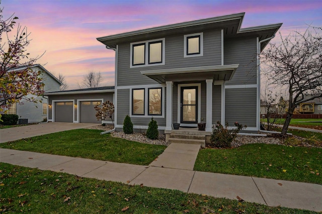 view of front of home with a yard and a garage