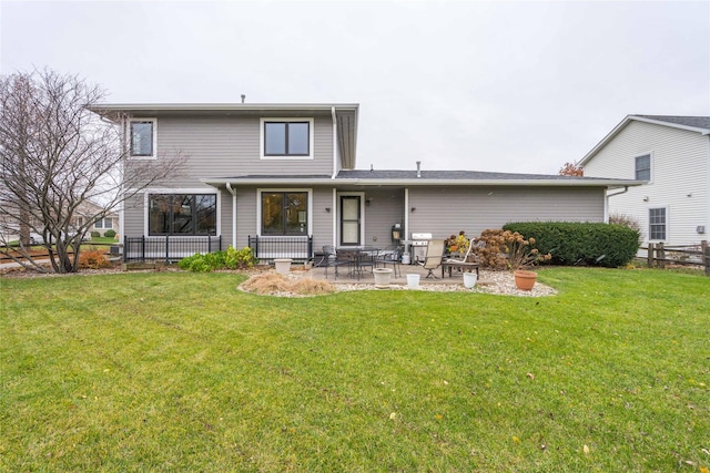 rear view of house featuring a lawn and a patio