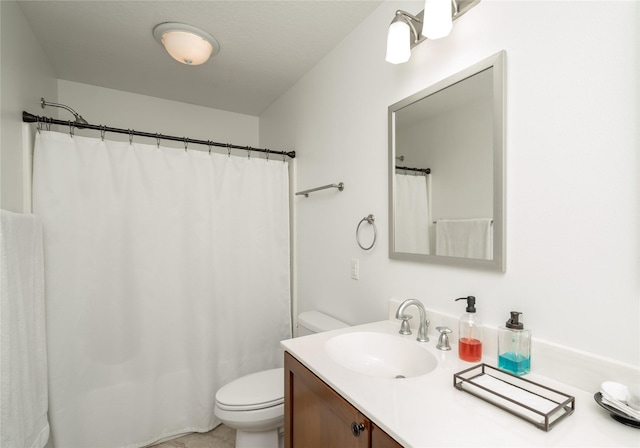 bathroom featuring toilet, vanity, and curtained shower