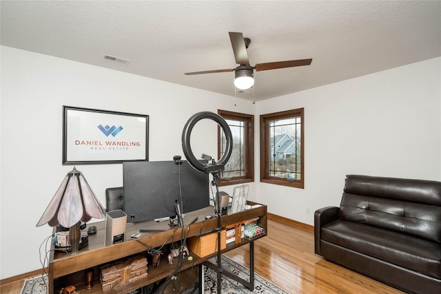 office area with a textured ceiling, ceiling fan, and hardwood / wood-style flooring