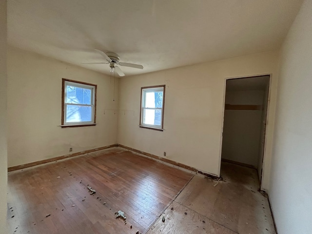 unfurnished bedroom with ceiling fan, a walk in closet, and a closet