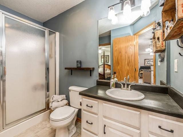 bathroom featuring a shower with door, vanity, a textured ceiling, tile patterned floors, and toilet