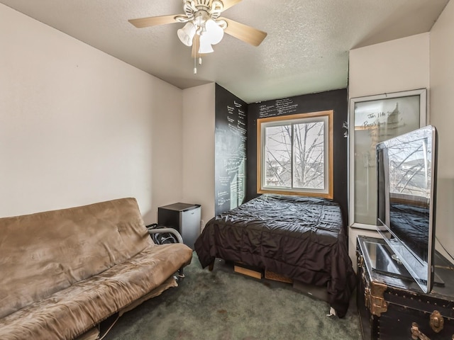 bedroom with ceiling fan, carpet flooring, and a textured ceiling