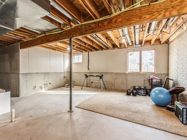 basement featuring plenty of natural light and brick wall